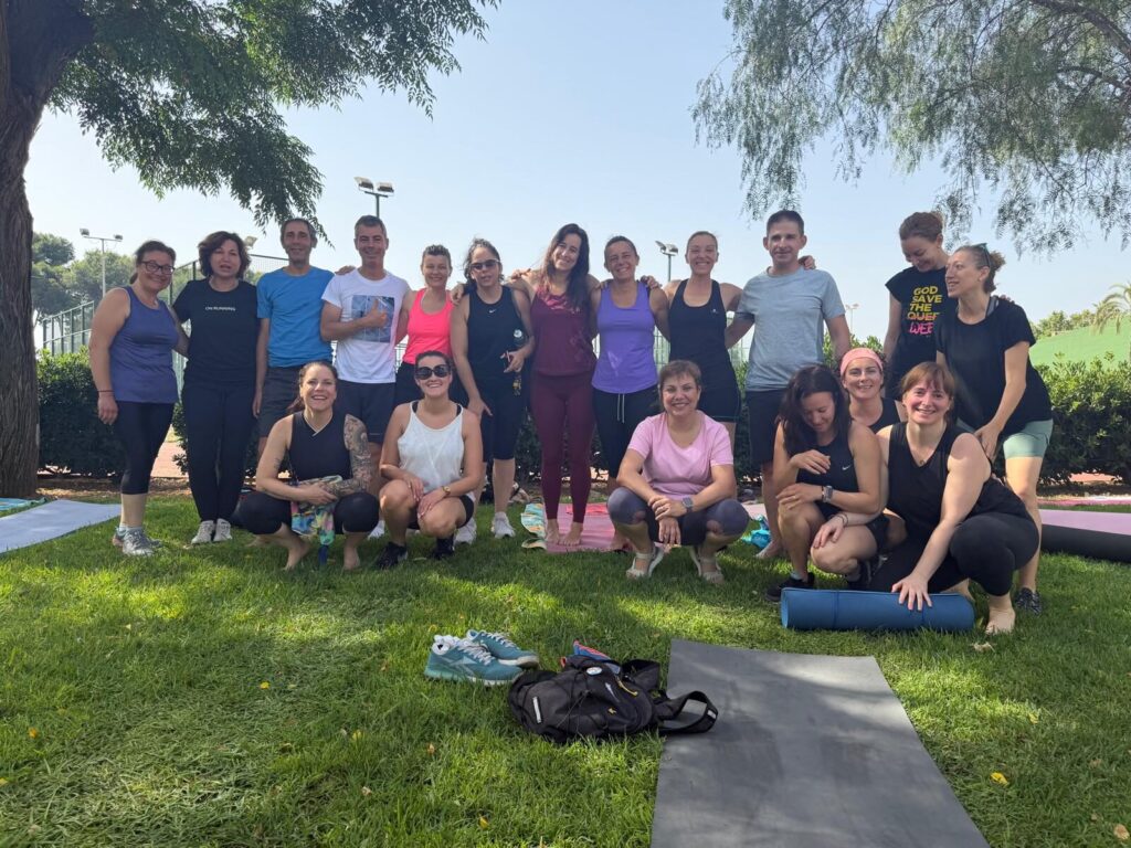 El grupo del encuentro posando en el césped del polideportivo de Picassent, bajo los árboles, con las esterillas en el suelo