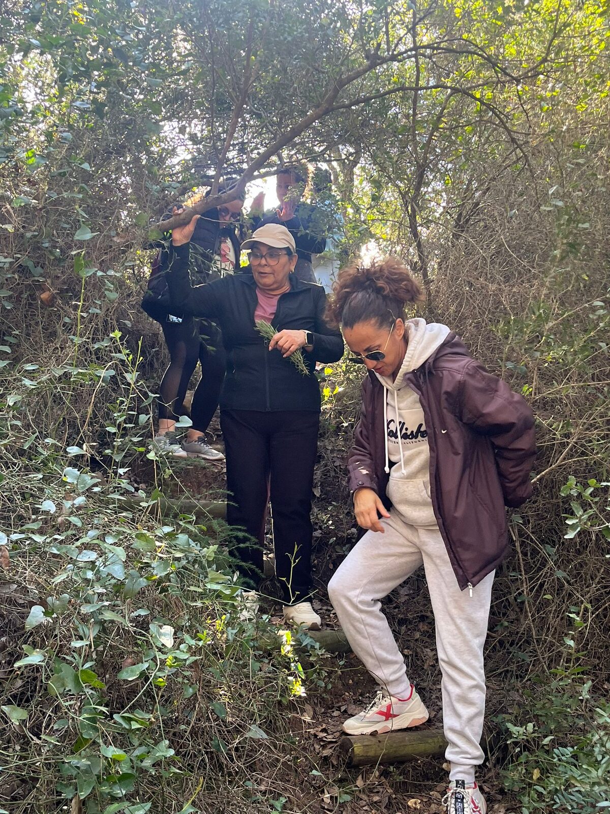 Tres participantes del retiro caminando entre la vegetación del monte de la Sierra de Espadán